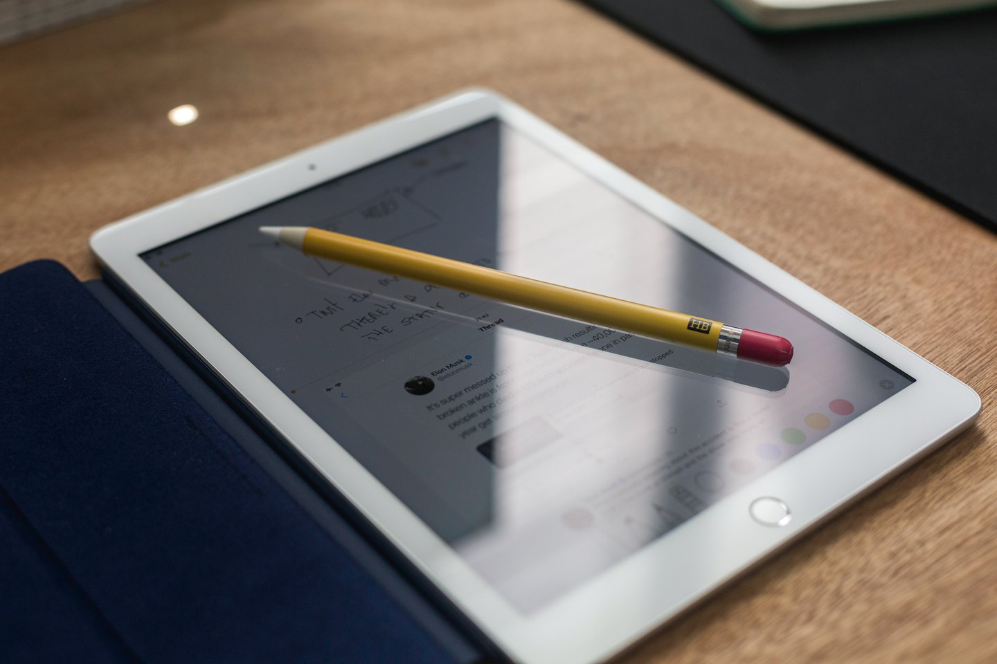 Tablet con stilo e appunti su una scrivania di legno.